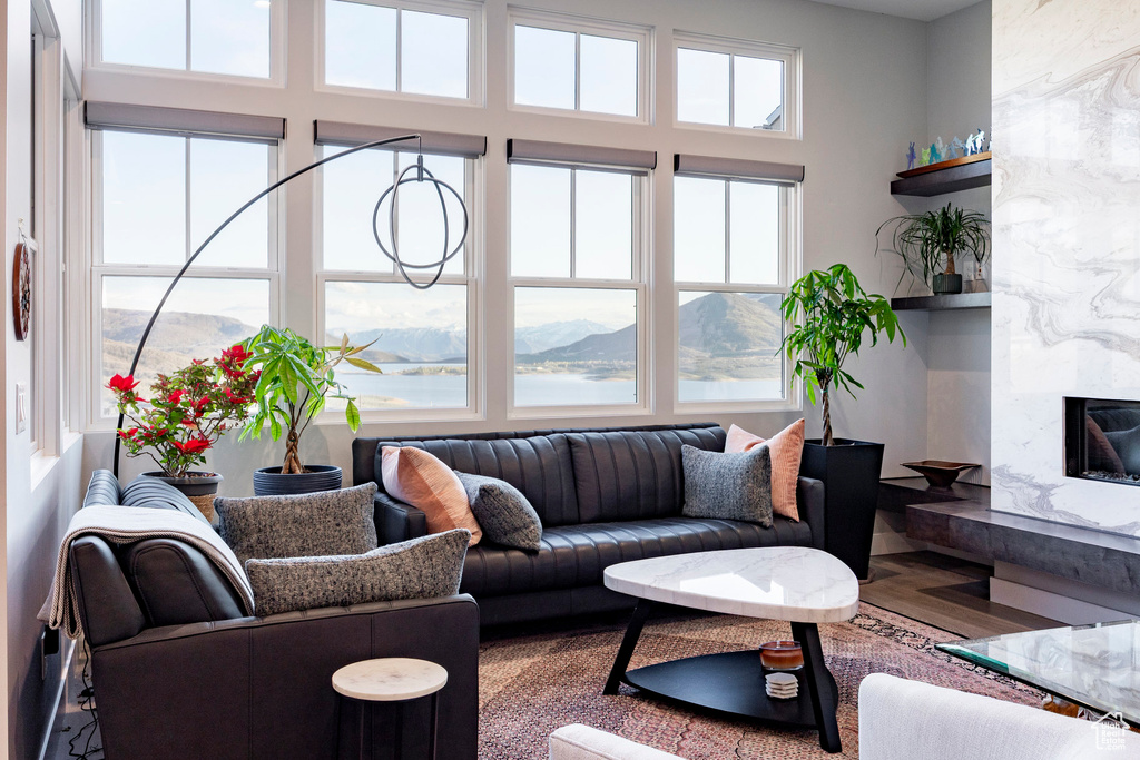 Living room with a high end fireplace, a mountain view, wood finished floors, and a wealth of natural light