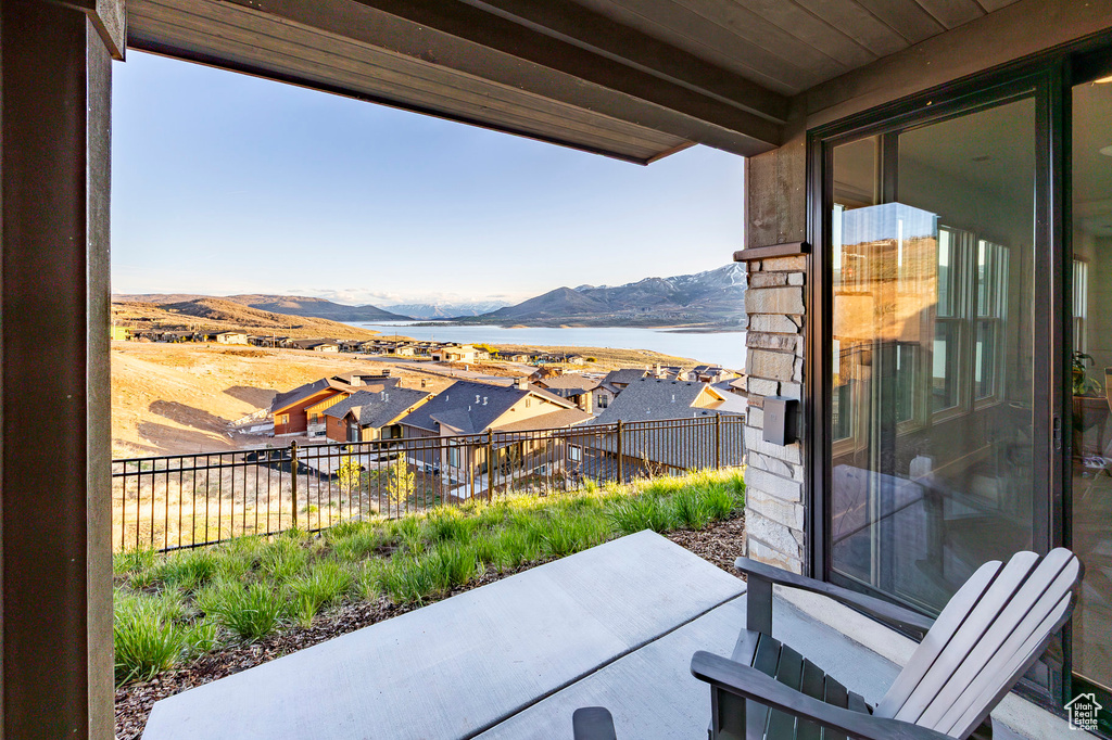 View of patio / terrace with a water and mountain view and a balcony