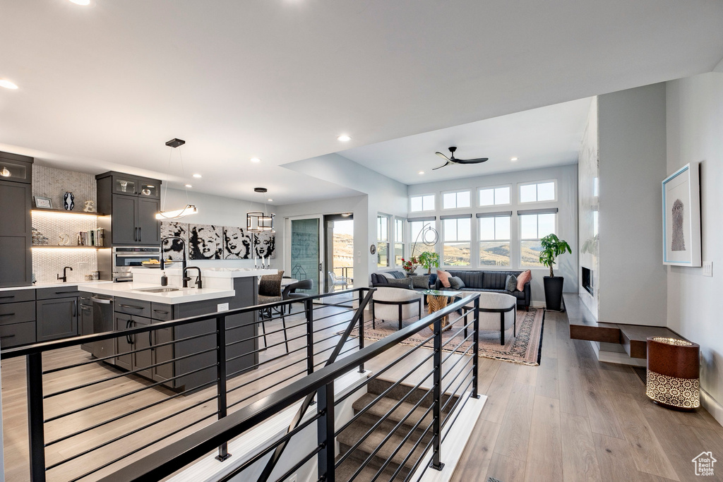 Kitchen featuring light countertops, backsplash, a sink, and a healthy amount of sunlight