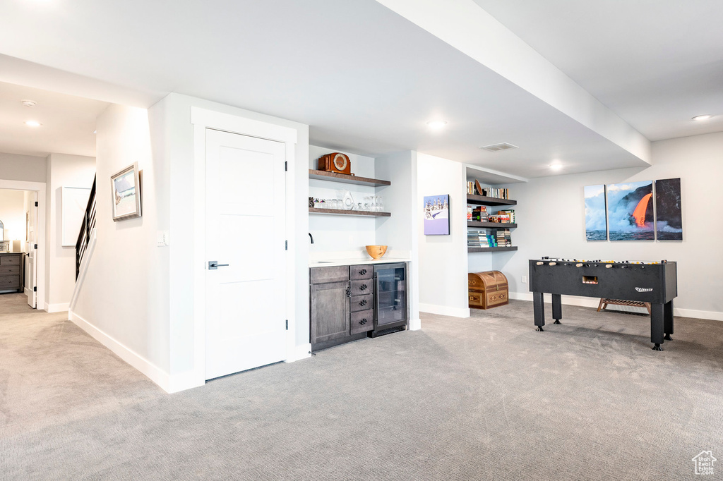 Rec room featuring carpet floors, bar area, beverage cooler, and visible vents