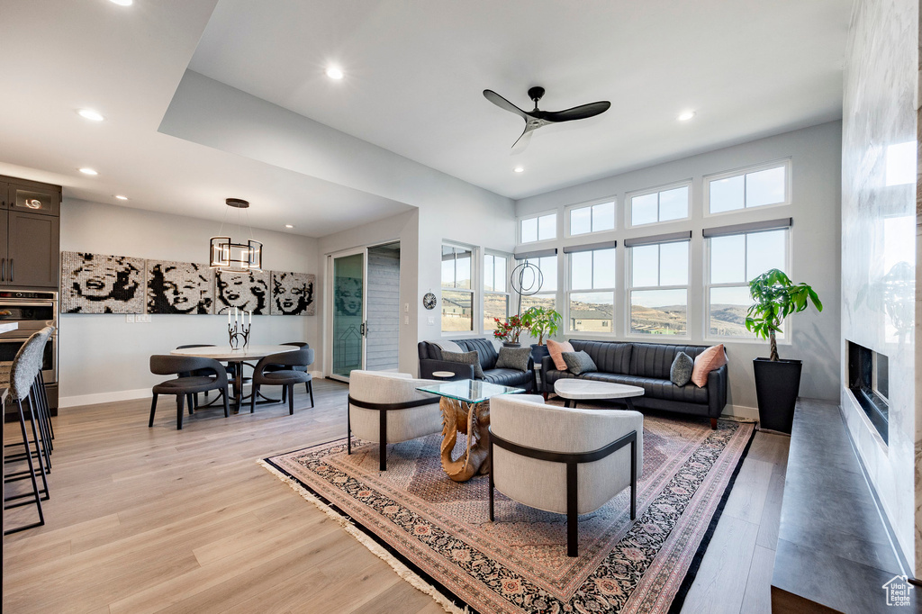 Living room featuring recessed lighting, ceiling fan, light wood-type flooring, and a premium fireplace