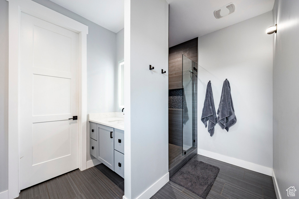 Full bathroom featuring vanity, baseboards, wood tiled floor, and a stall shower