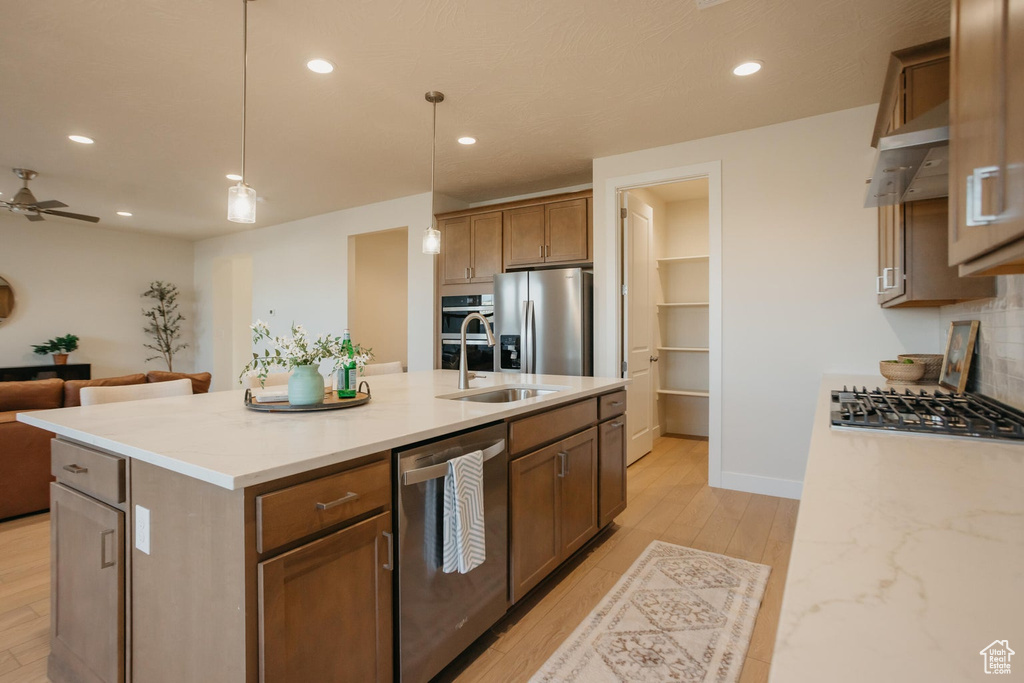 Kitchen featuring decorative light fixtures, stainless steel appliances, open floor plan, and recessed lighting
