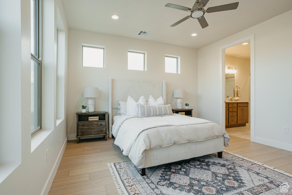 Bedroom with baseboards, visible vents, multiple windows, and light wood-style floors