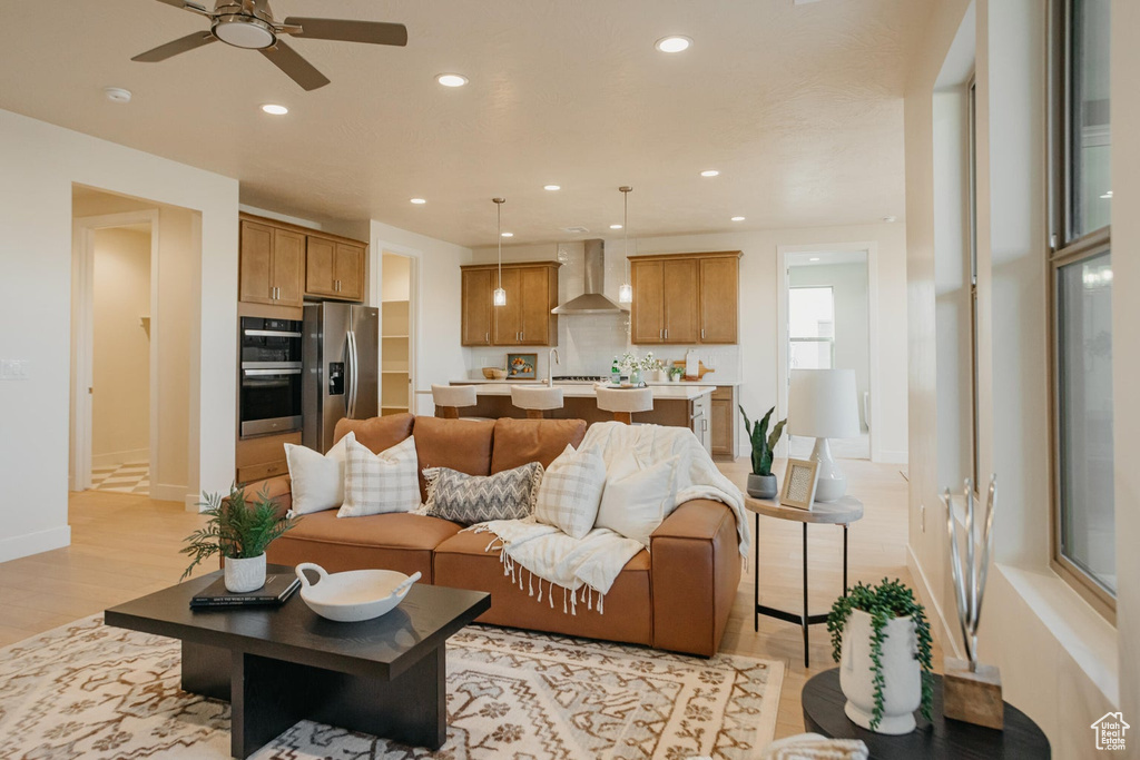 Living area with light wood-style floors, recessed lighting, baseboards, and a ceiling fan