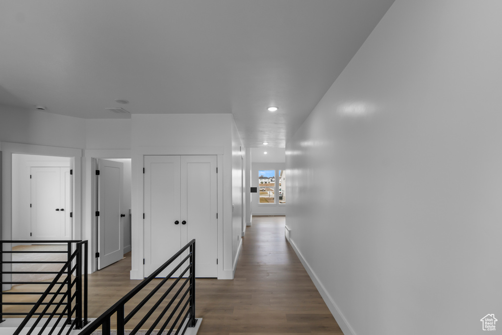 Hallway with recessed lighting, baseboards, an upstairs landing, and wood finished floors