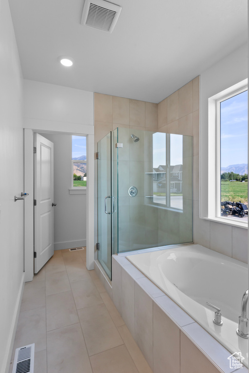 Full bathroom with visible vents, tile patterned floors, a bath, and a shower stall