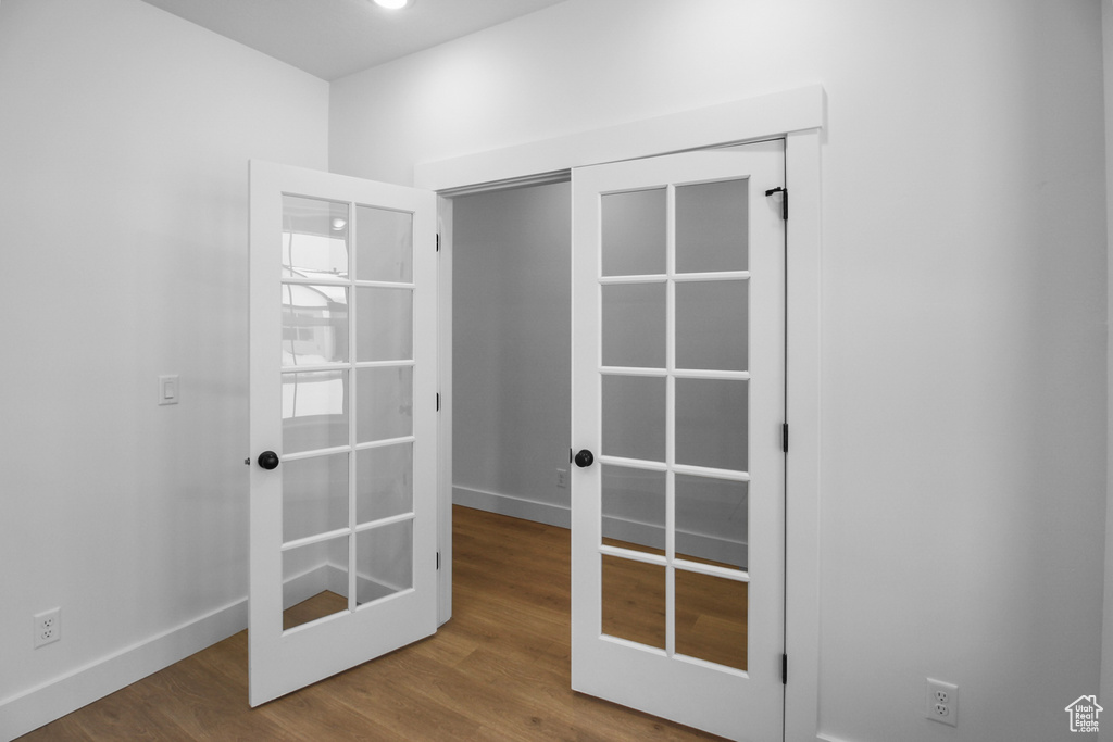 Interior space featuring baseboards, french doors, and wood finished floors
