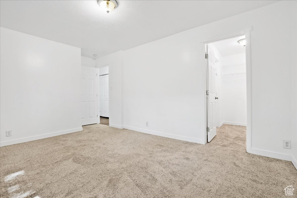 Spare room featuring carpet floors and baseboards