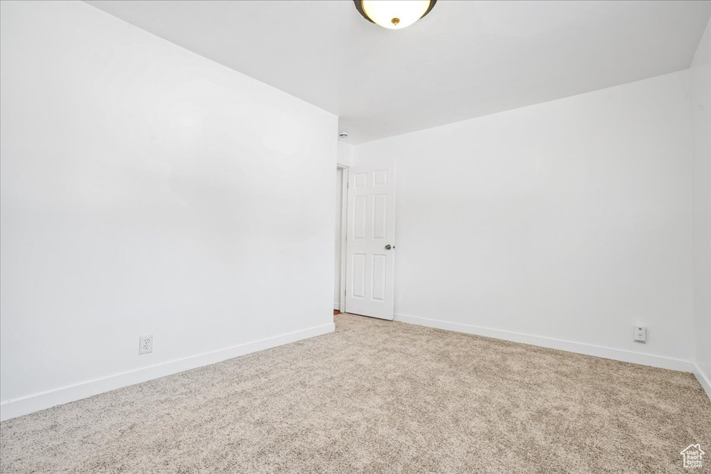 Spare room featuring baseboards and light carpet