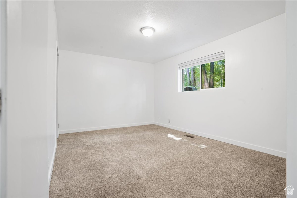 Empty room featuring baseboards and carpet