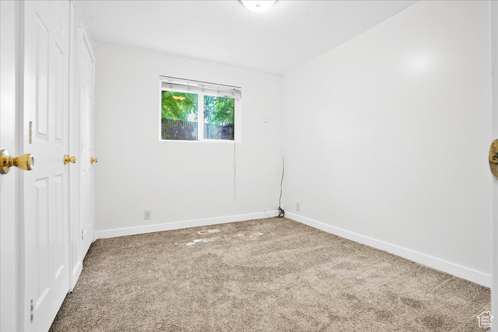 Empty room with carpet floors and baseboards