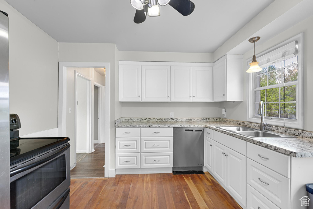 Kitchen featuring ceiling fan, white cabinetry, hardwood / wood-style flooring, a sink, and appliances with stainless steel finishes