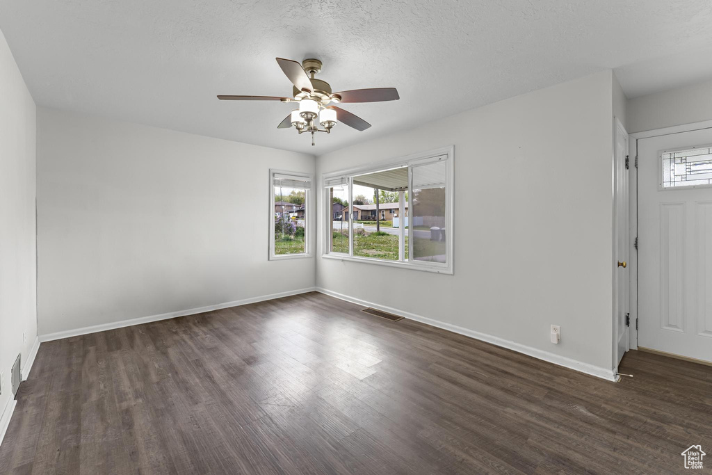 Spare room featuring a ceiling fan, baseboards, visible vents, and wood finished floors