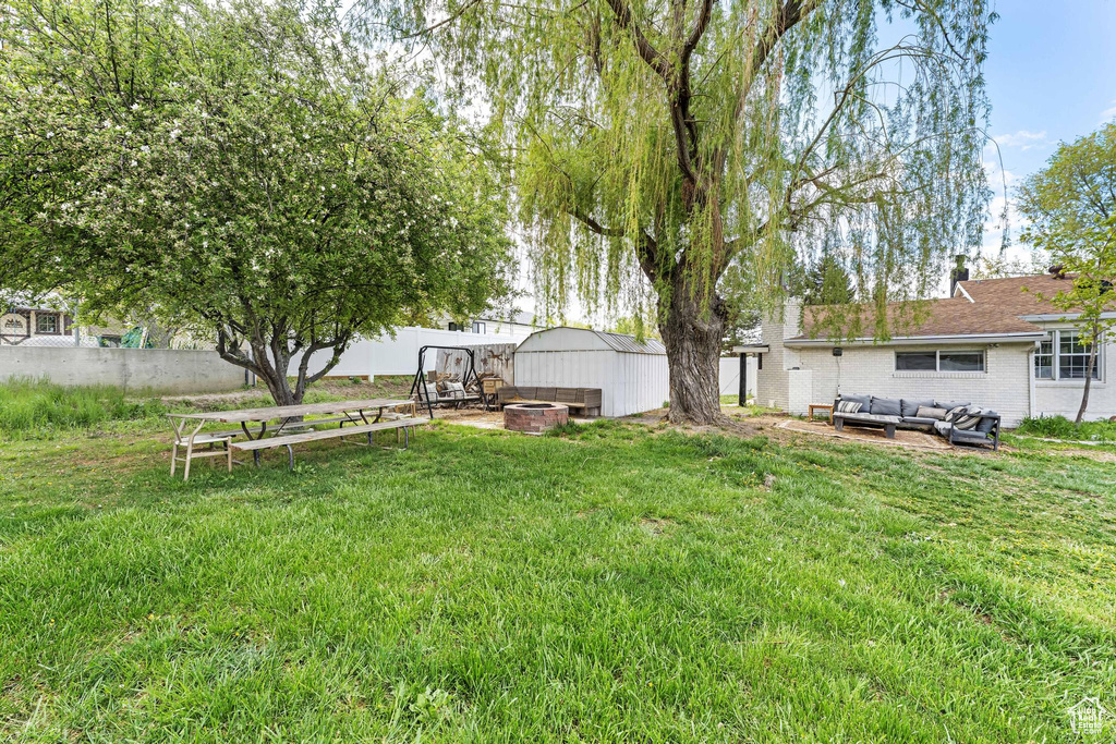 View of yard with an outdoor living space with a fire pit, a shed, and an outbuilding