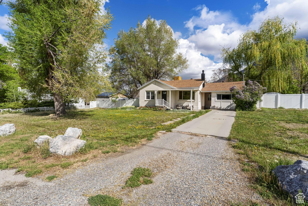 View of front of home featuring a porch, fence, driveway, and a chimney