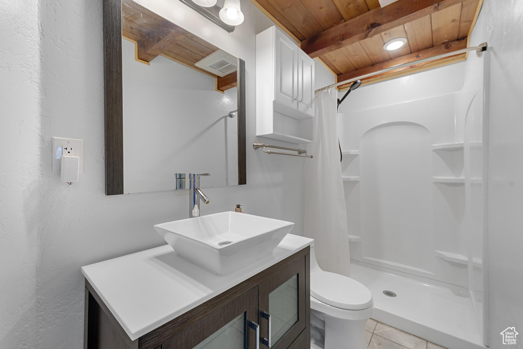 Full bathroom featuring beam ceiling, a stall shower, toilet, and wooden ceiling