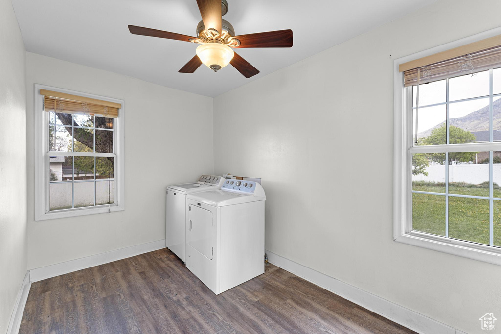 Laundry room featuring a healthy amount of sunlight, laundry area, washing machine and dryer, and dark wood-style floors