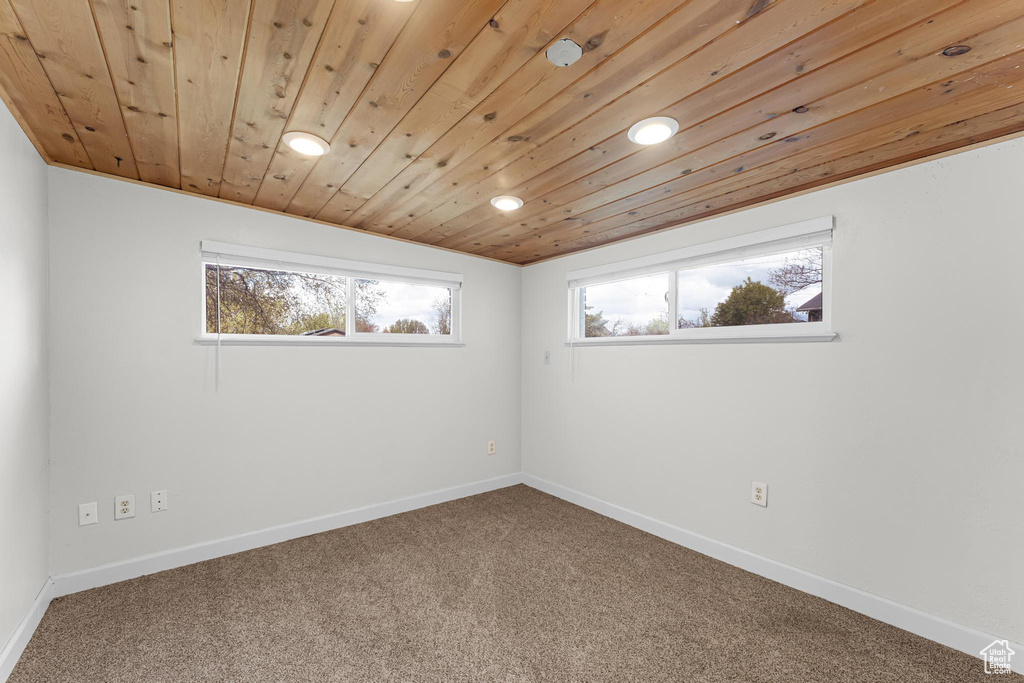 Carpeted spare room with wood ceiling, baseboards, and recessed lighting