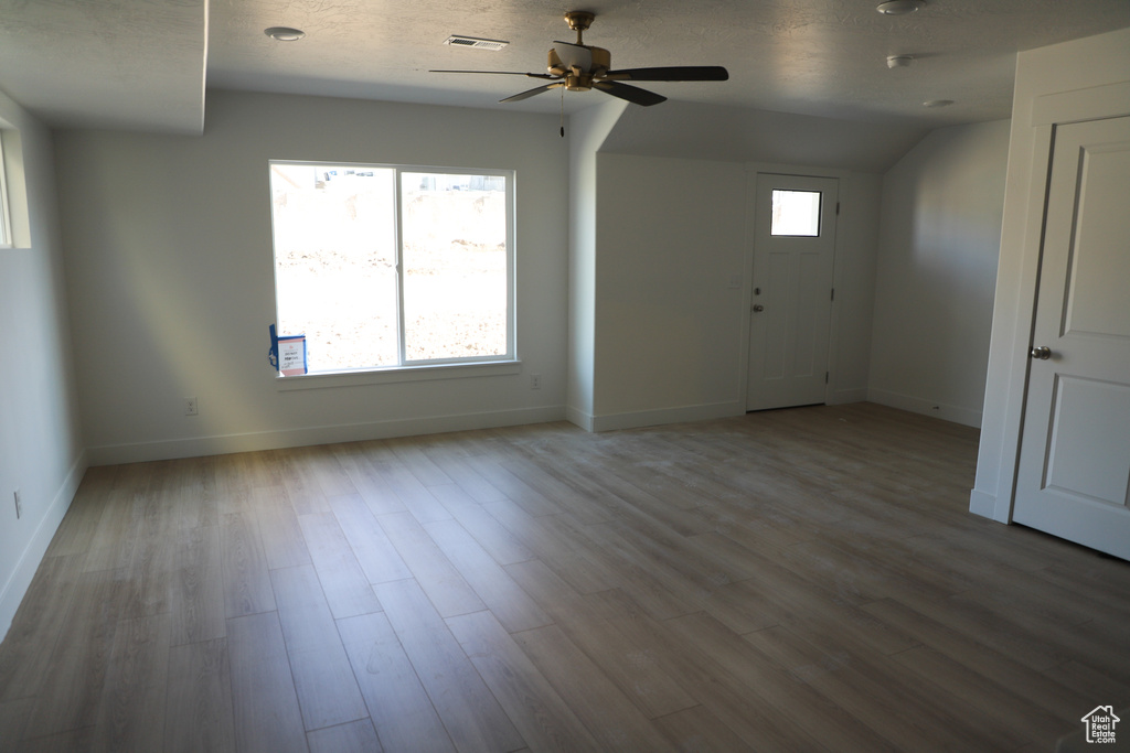 Interior space with baseboards, a ceiling fan, wood finished floors, and visible vents