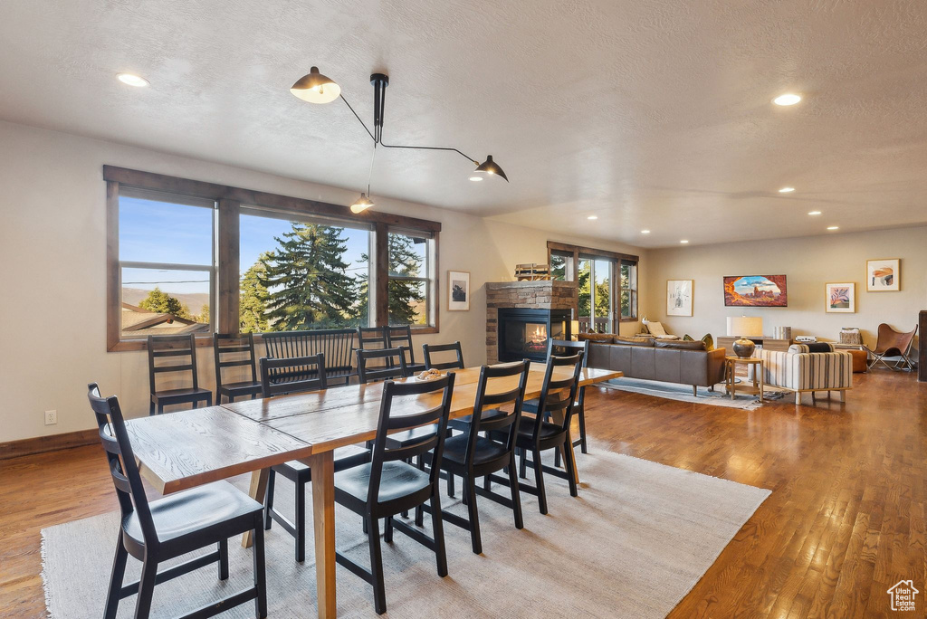 Dining room with recessed lighting, a glass covered fireplace, and wood finished floors