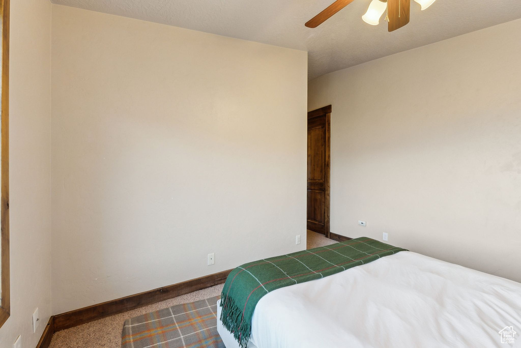 Bedroom with baseboards, ceiling fan, and carpet