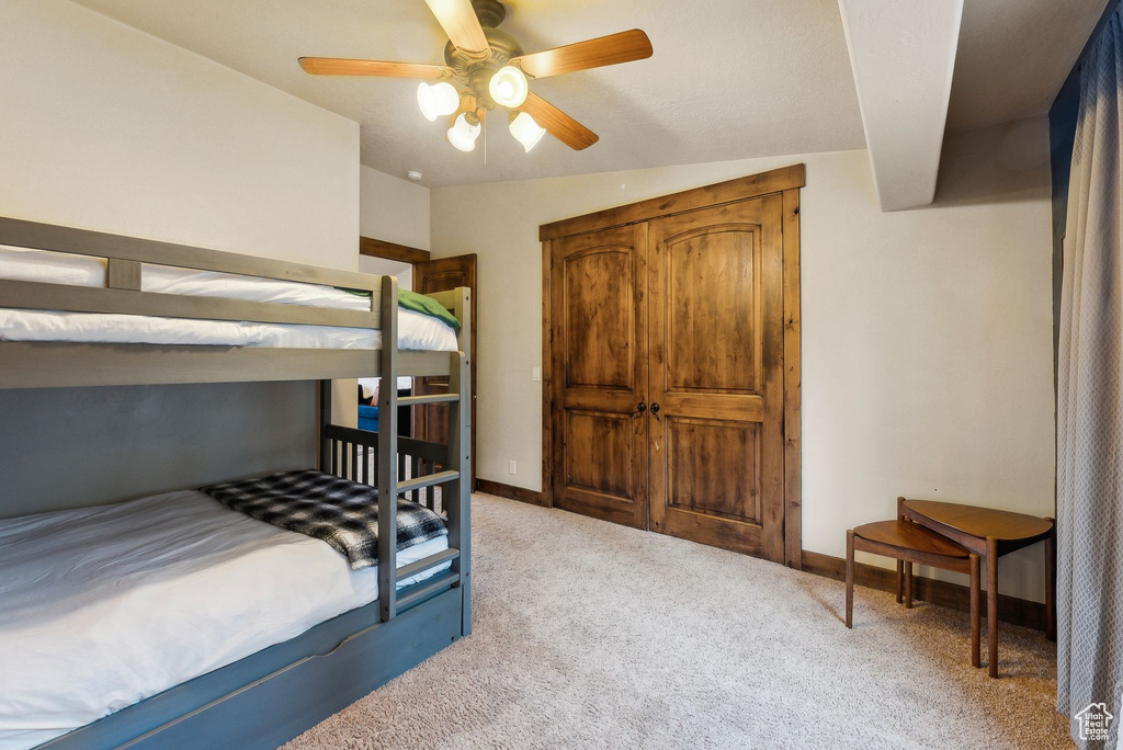 Bedroom featuring baseboards, light carpet, and a ceiling fan