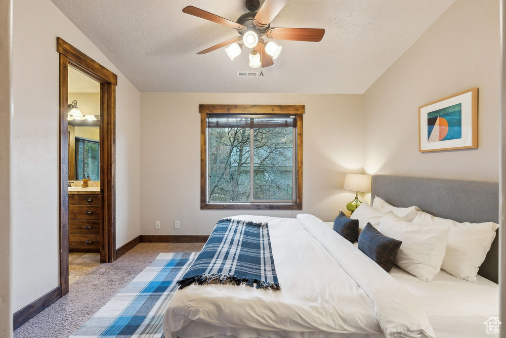 Bedroom with a ceiling fan, visible vents, baseboards, carpet, and ensuite bath
