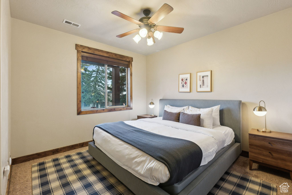 Bedroom with visible vents, carpet flooring, baseboards, and a ceiling fan