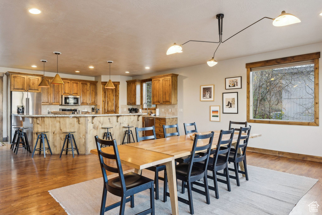 Dining room with a healthy amount of sunlight, baseboards, light wood finished floors, and recessed lighting