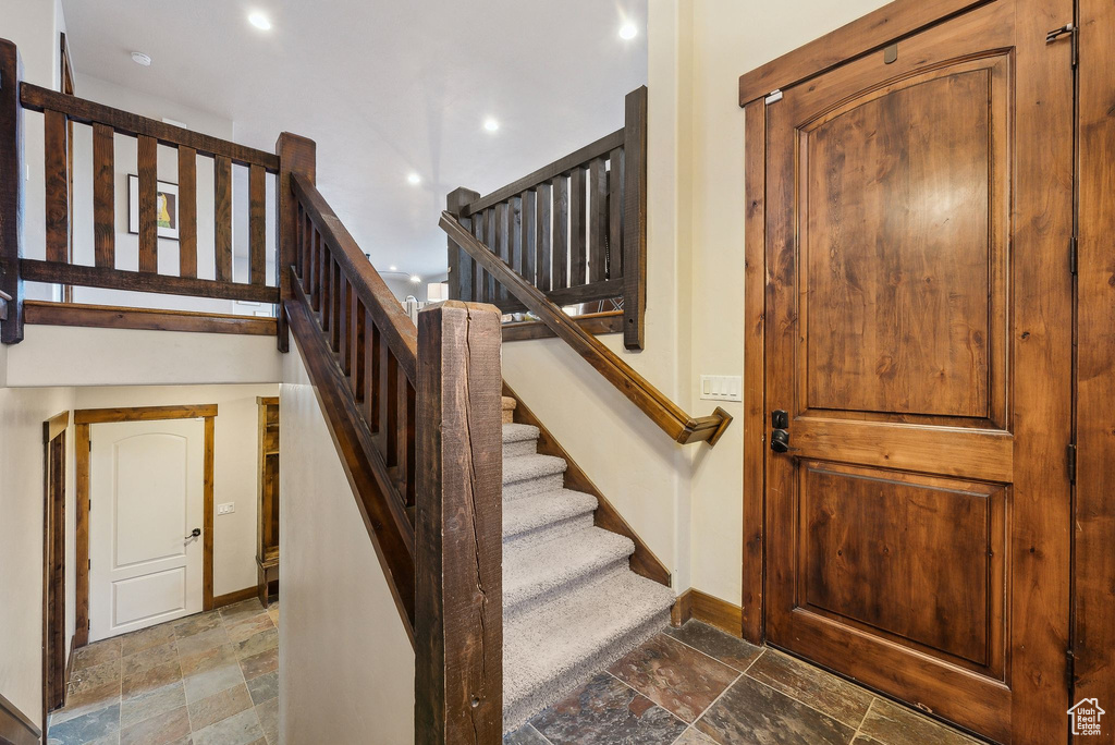 Staircase with baseboards, recessed lighting, and stone tile floors