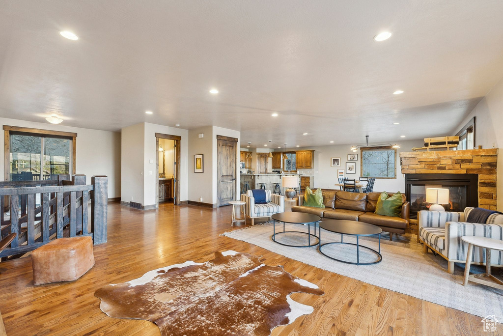 Living area with baseboards, a fireplace, recessed lighting, and wood finished floors