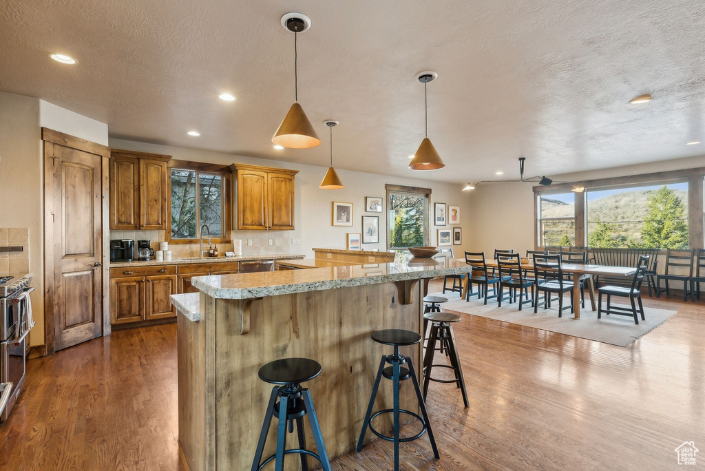 Kitchen with a kitchen breakfast bar, brown cabinetry, and wood finished floors