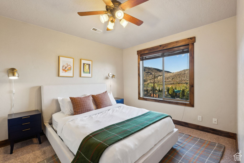 Bedroom featuring baseboards, ceiling fan, and carpet floors