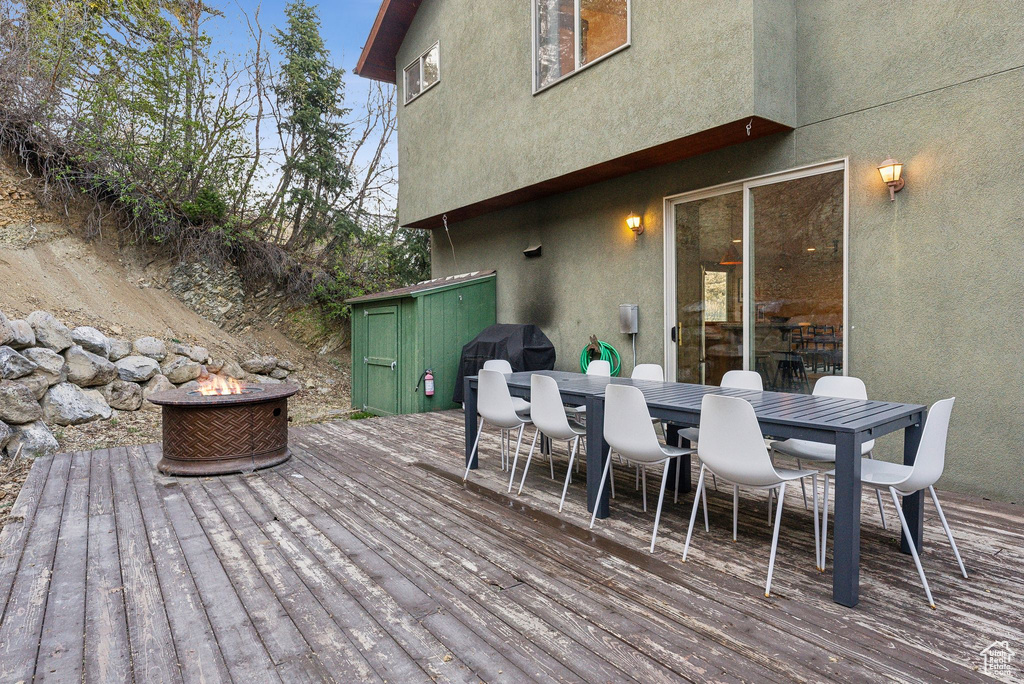 Deck with area for grilling, outdoor dining space, and an outdoor fire pit