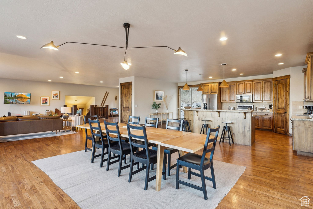 Dining area with light wood finished floors and recessed lighting