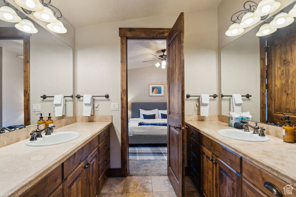Bathroom featuring a sink, ceiling fan, two vanities, and connected bathroom
