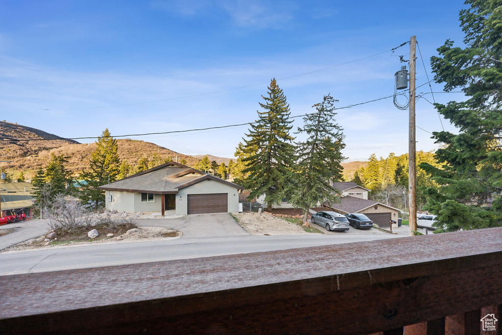 Exterior space with an attached garage, a mountain view, and concrete driveway