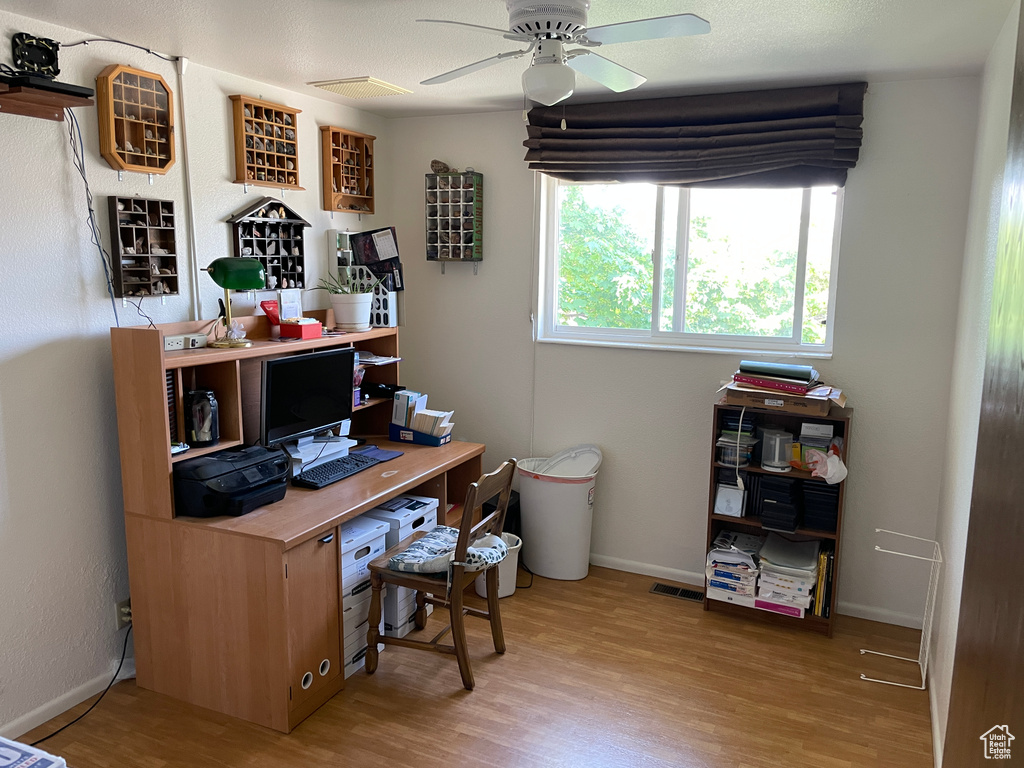 Office area with baseboards, ceiling fan, visible vents, and wood finished floors