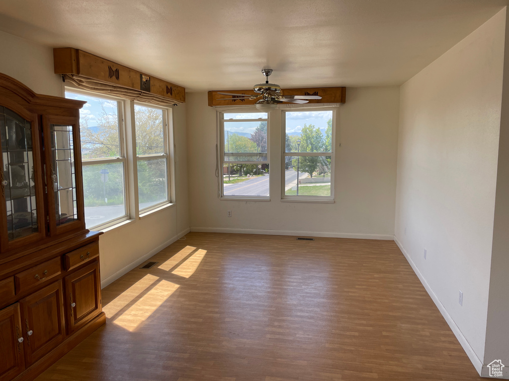 Spare room featuring baseboards, visible vents, and wood finished floors