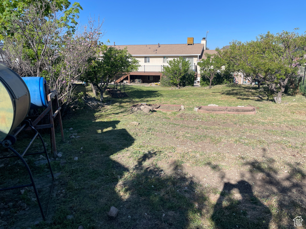View of yard featuring a wooden deck and stairs