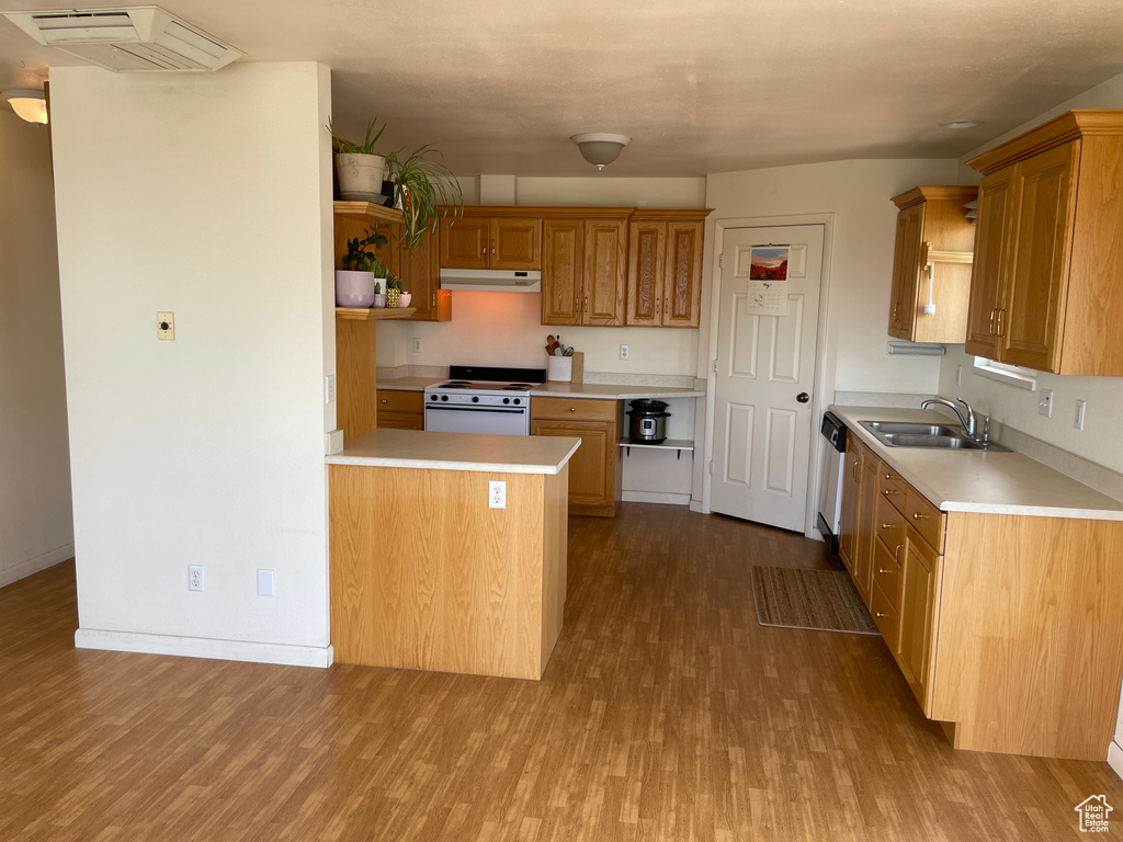 Kitchen featuring open shelves, wood finished floors, white electric range, under cabinet range hood, and a sink