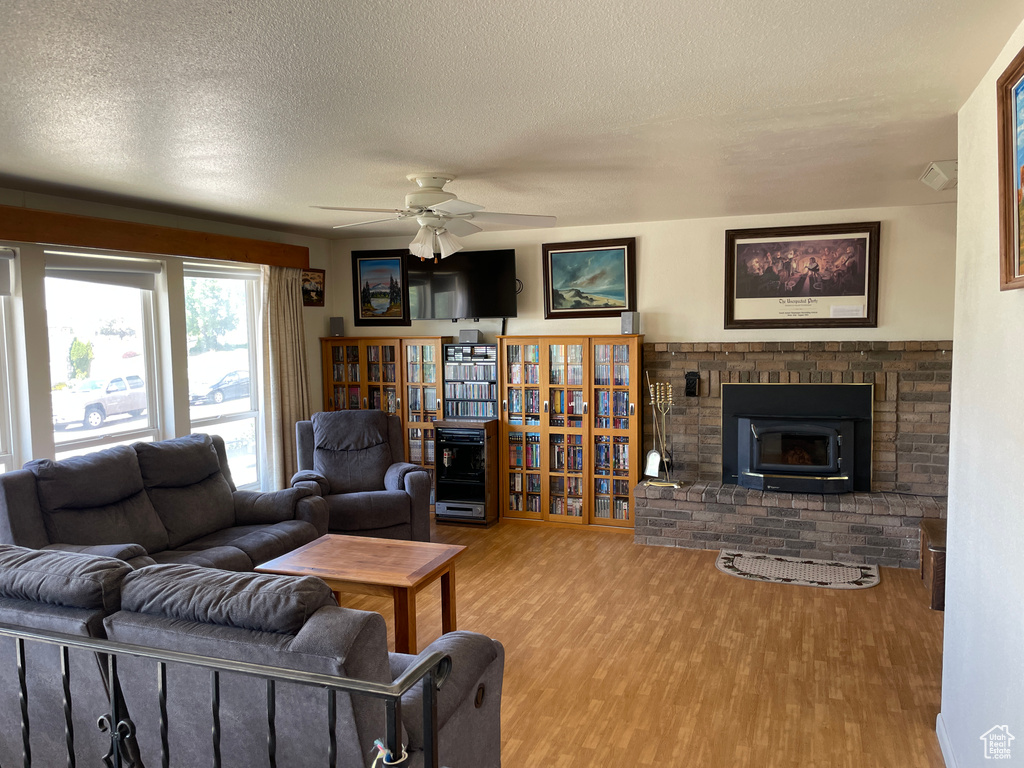 Living area featuring a ceiling fan, a textured ceiling, and wood finished floors