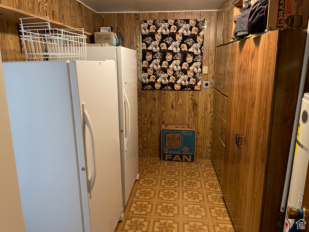 Kitchen with wooden walls and freestanding refrigerator