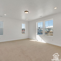 Carpeted empty room with recessed lighting and baseboards