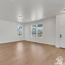Unfurnished living room with baseboards, recessed lighting, and wood finished floors