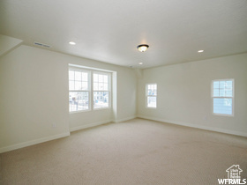 Empty room with recessed lighting, baseboards, visible vents, and light carpet