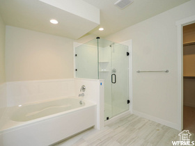 Full bath featuring a garden tub, visible vents, a stall shower, a spacious closet, and recessed lighting