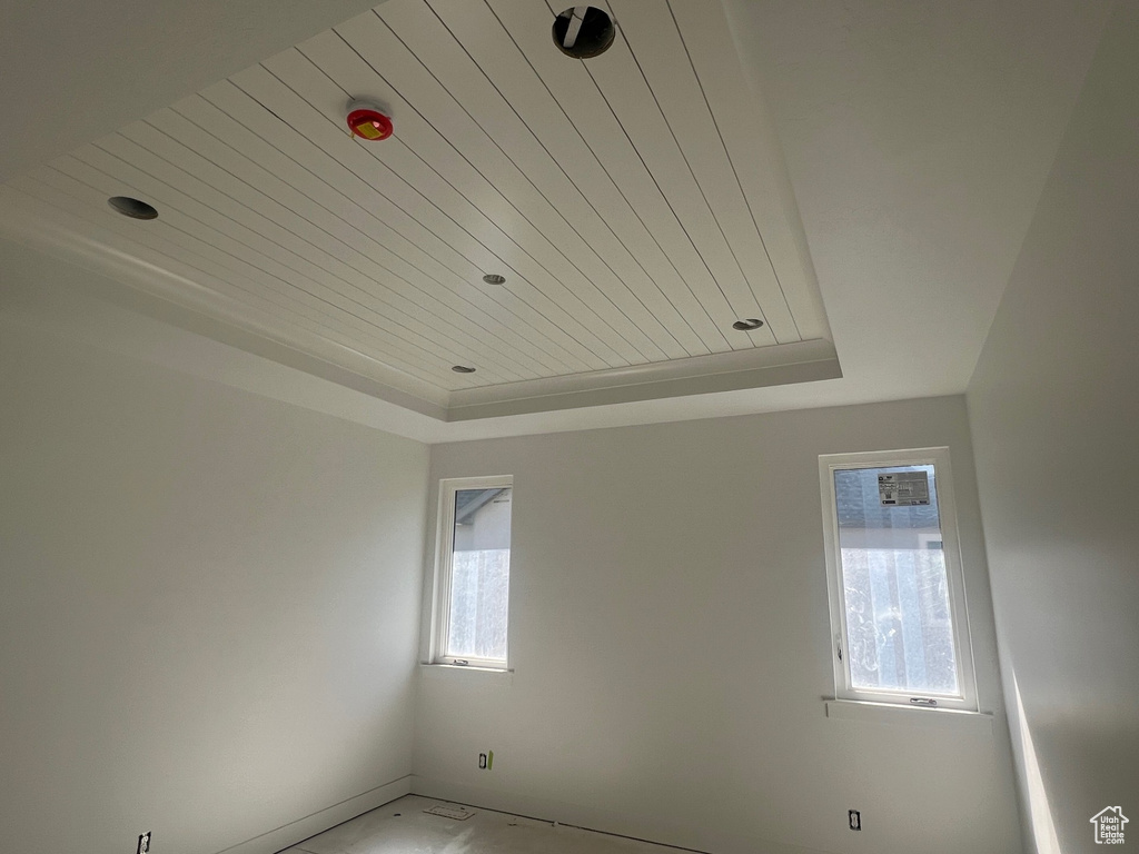Unfurnished room with a tray ceiling and wood ceiling