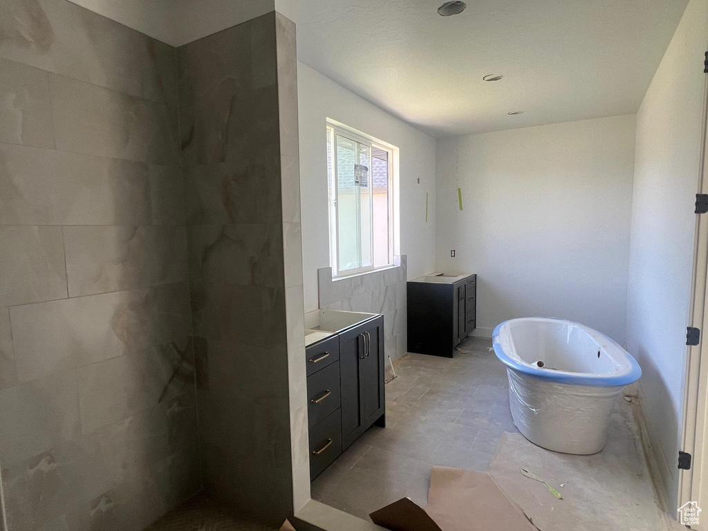Full bath with vanity, a soaking tub, and walk in shower